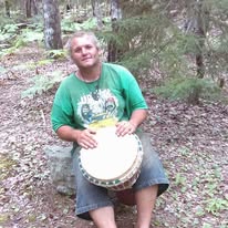 A loved one sitting outdoors with a drum