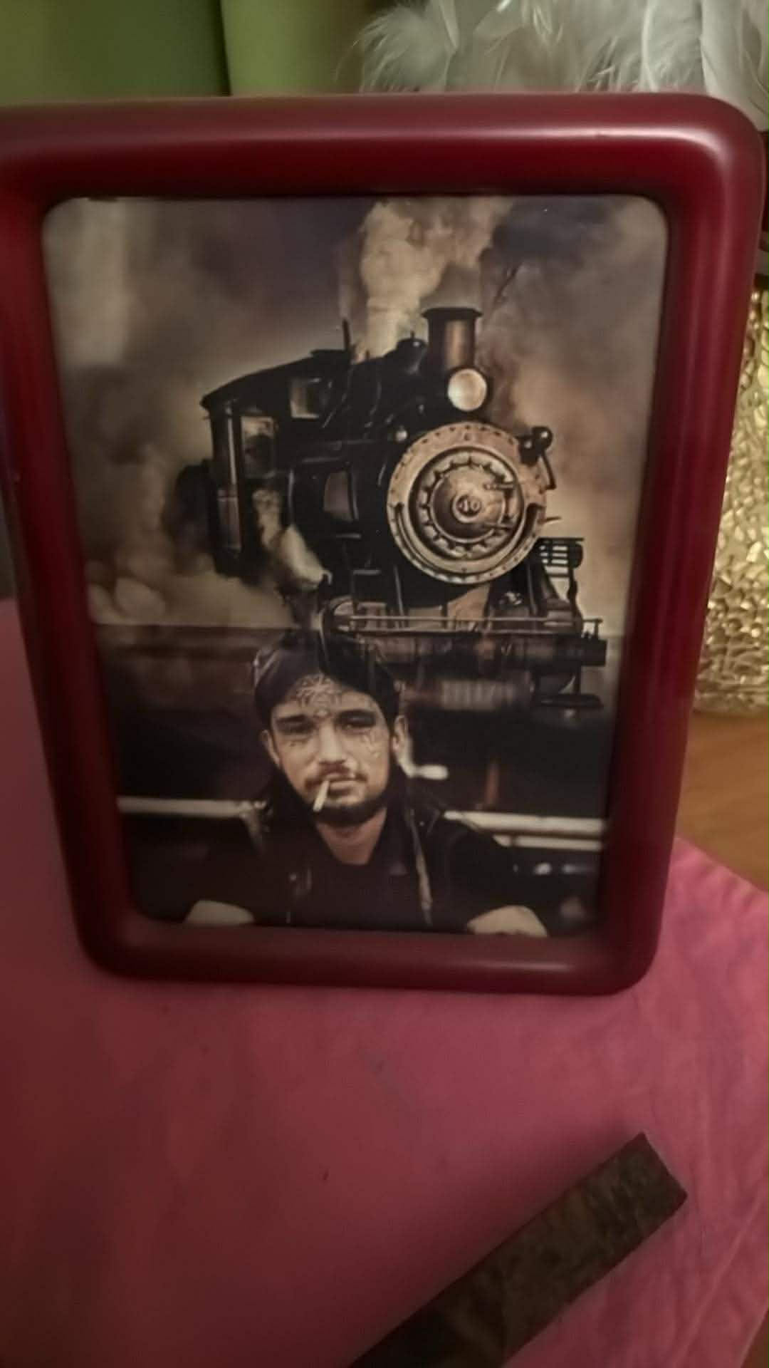 A framed memorial portrait with a steam train