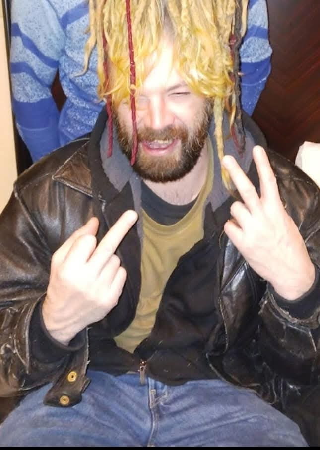 A loved one smiling with dyed hair and a leather jacket