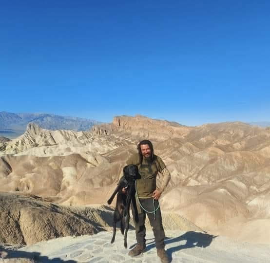 A loved one standing with a dog in desert hills